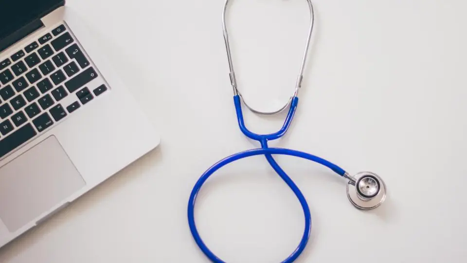 A stethoscope beside a laptop